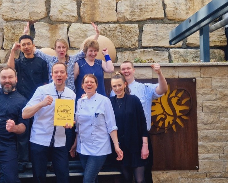 Das Team des Hotel Gasthof zur Sonne vor der Natursteinwand im Haus